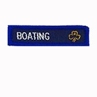blue rectangle woven badge with the word boating sewn in white in capital letters and a gold trefoil after the writing
