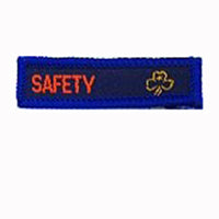 blue rectangle woven badge with the word safety sewn in red in capital letters and a gold trefoil after the writing