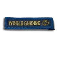 blue rectangle woven badge with the words world guiding sewn in gold in capital letters and a gold trefoil after the writing