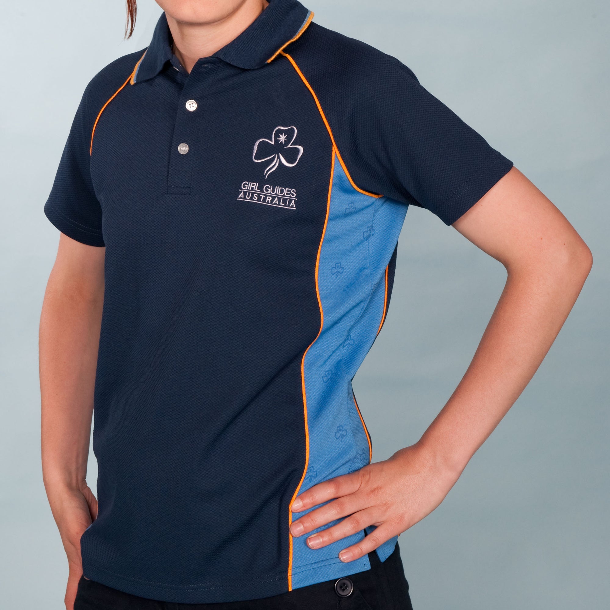 navy blue polo shirt with light blue inserts in the sides with gold trim with the trefoil and girl guides Australia on the left top section, available in sizes ranging from six to thirty eight