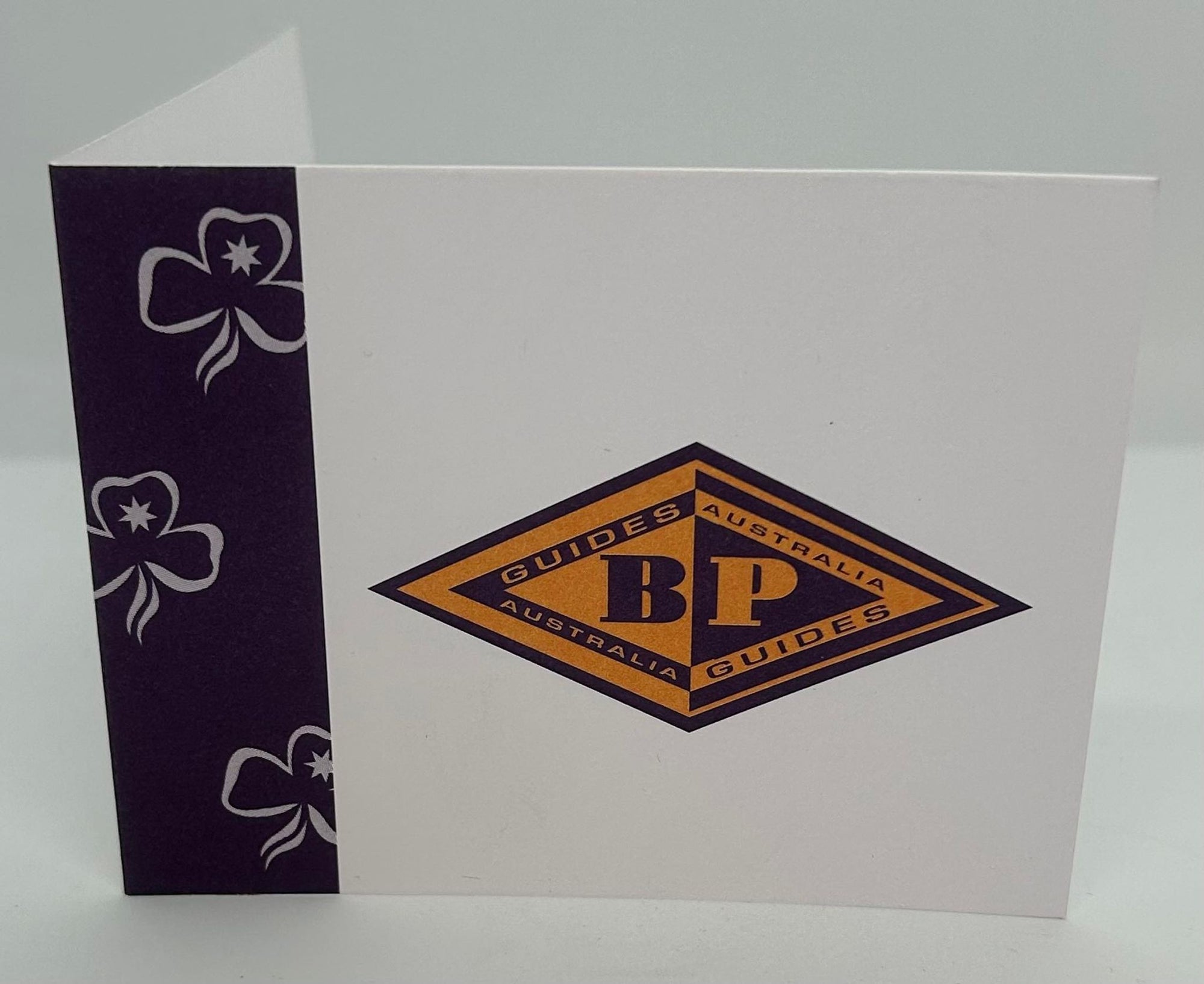 a small card with the BP symbol on the front with trefoils down the side that is blank on the inside