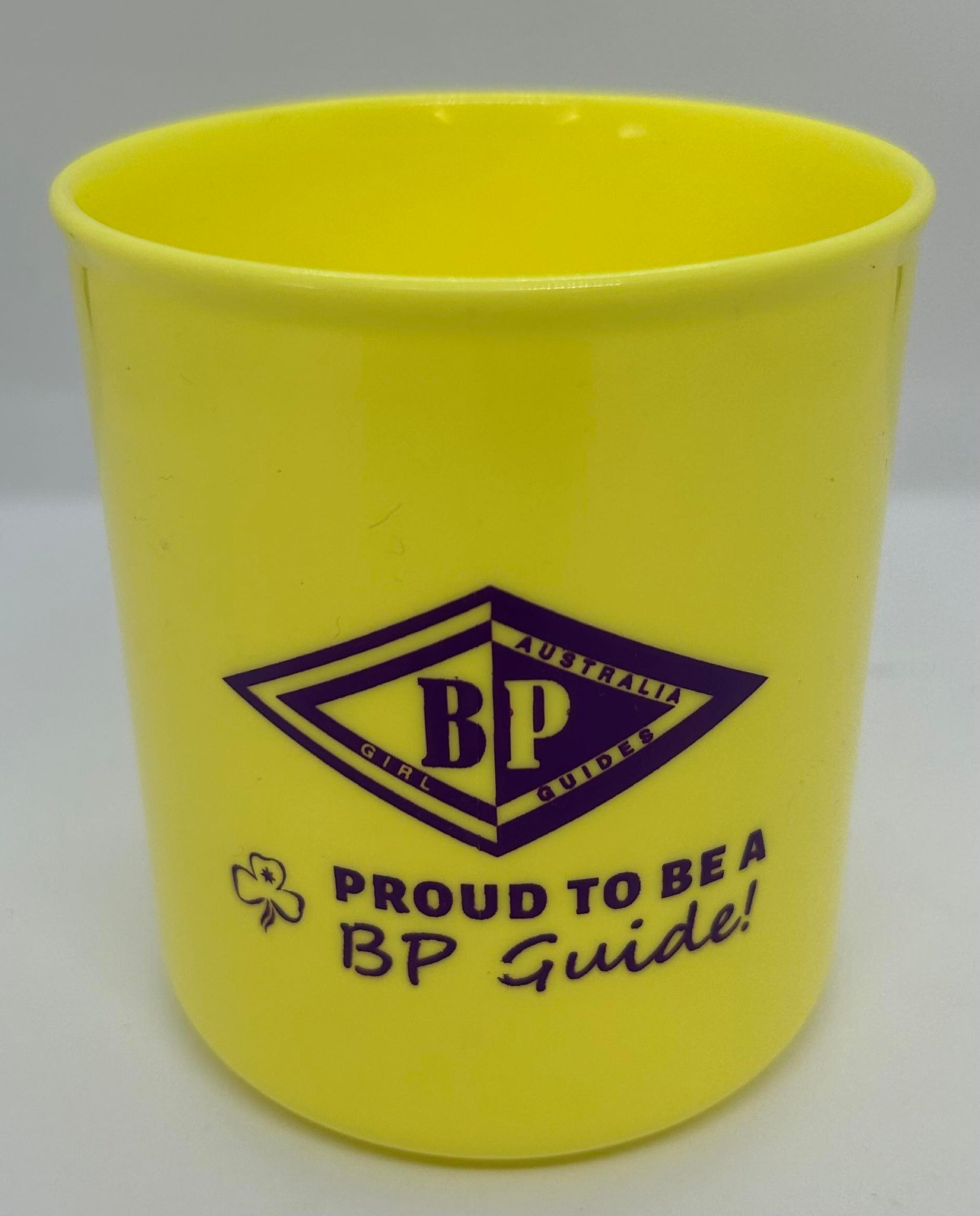 a yellow plastic cup with the BP symbol and proud to be a BP guide written in purple on the front