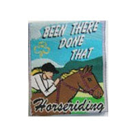 unbound cloth badge that shows a girl on a horse in the outdoors