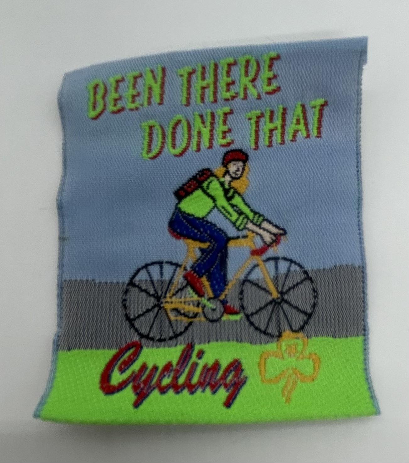 an unbound square badge with a girl on a bike