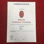 a certificate that marks your progress in the awards of Junior BP, BP and Queens Guide. The certificate is white with a bronze endeavour badge printed on it.