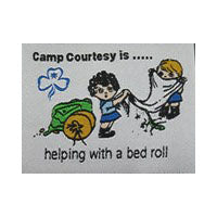 Unbound fun badge with  embroidered picture of two Guides making a bedroll on a white background 
