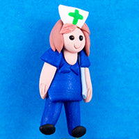 clay brooch with a woman dressed in blue scrubs with a white hat with a green cross on the front of it