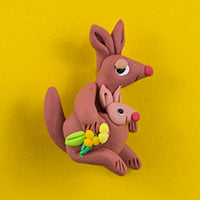 Clay Brooch in shape of Kangaroo with Joey in pouch - coloured brown. Kangaroo is holding a sprig of wattle
