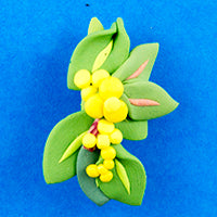 handmade clay badge with green leaves and golden wattle