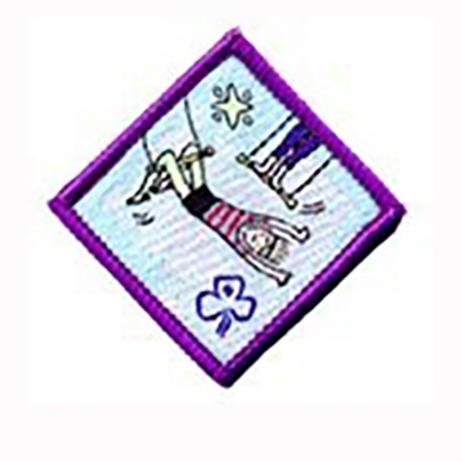 diamond shape bound in purple badge with a girl hanging on a trapeze by her legs with a star at the top
