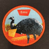 round badge with an emu bound in orange