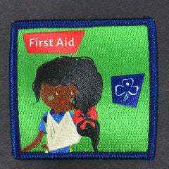 a square badge bound in blue with a green background with a guide with her arm in a sling