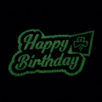 bound badge that says happy birthday in white that glows green in the dark