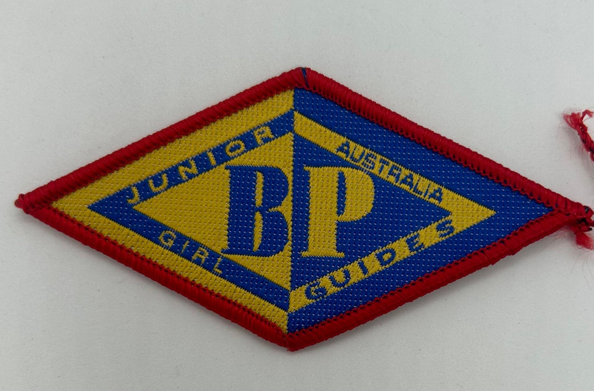 a diamond shaped cloth badge with the JBP logo