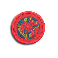 a round badge bound in red with a flowering gum on it