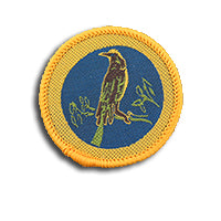 a round badge bound in gold with a honeyeater bird on it