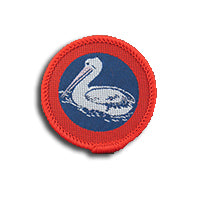 a round badge bound in red with a pelican on it