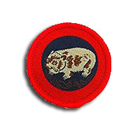 a round badge bound in red with a wombat on it