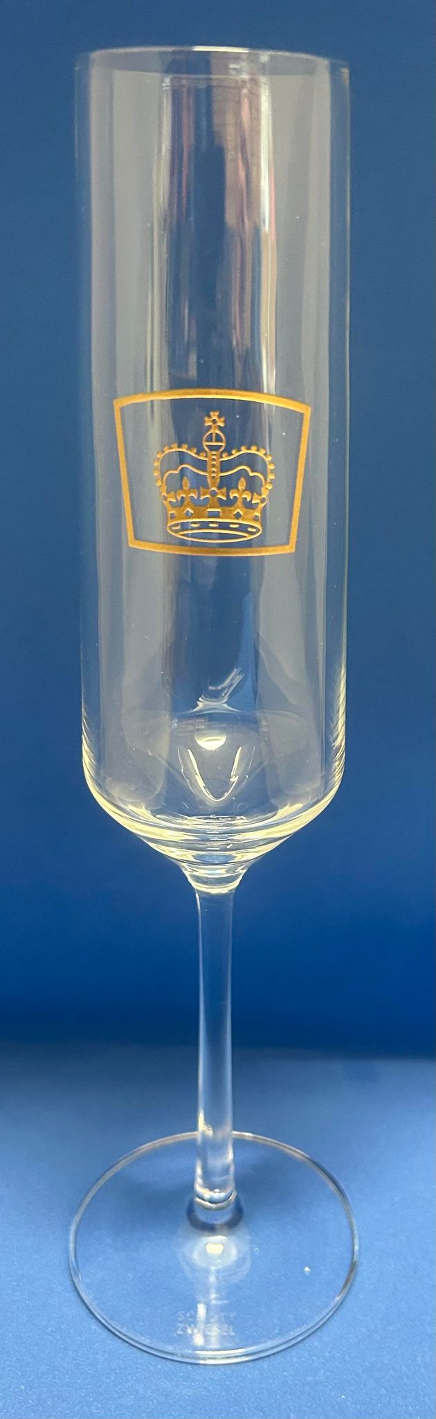 a champagne flute with the queens guide emblem etched in gold