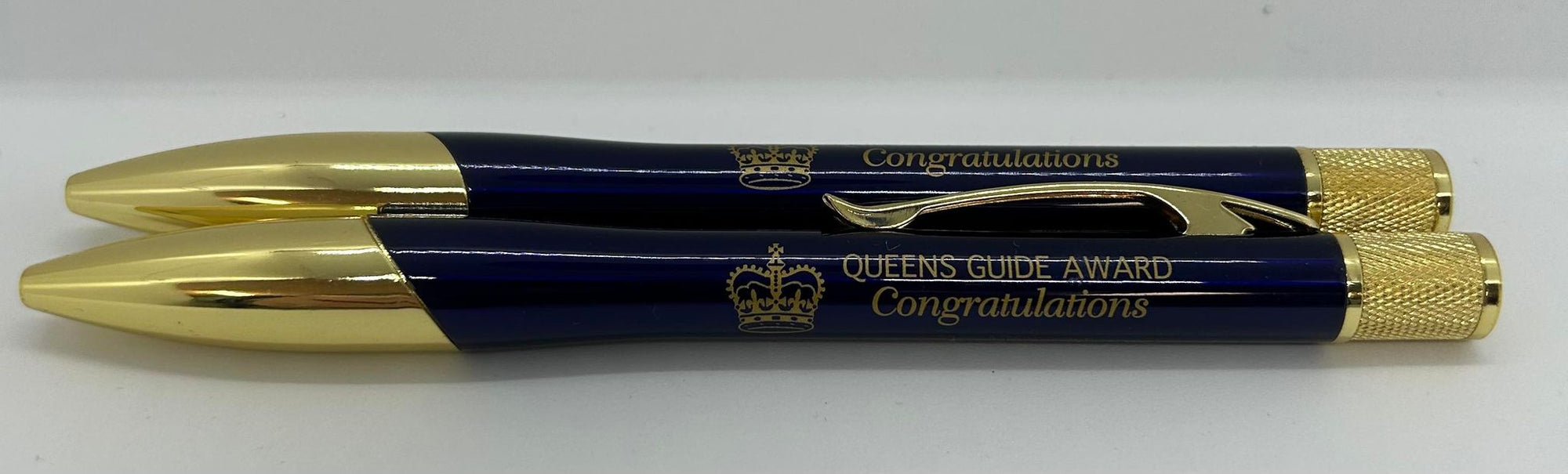 a blue and gold pen with queens guide congratulations on it