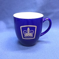 a blue coffee mug with a gold crown on the front
