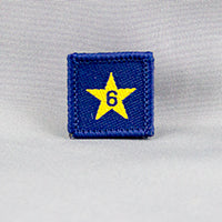 square blue badge with gold star with the number six in the centre written in blue