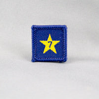 square blue badge with a gold star with the number seven in the centre written in blue