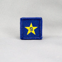 square blue badge with a gold star with the number nine in the centre written in blue