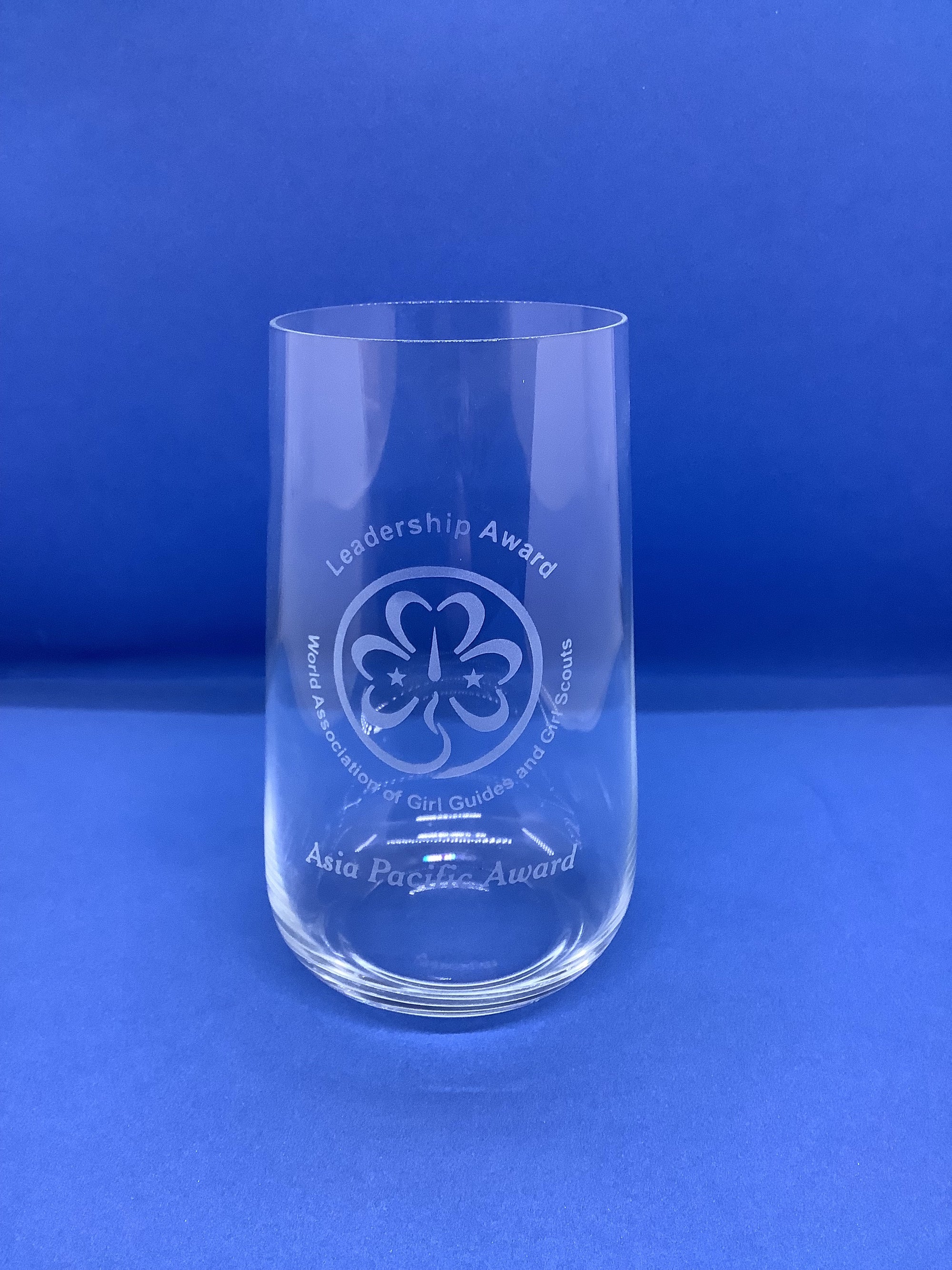clear glass tumbler with the Asia Pacific symbol and Leadership Award etched into it
