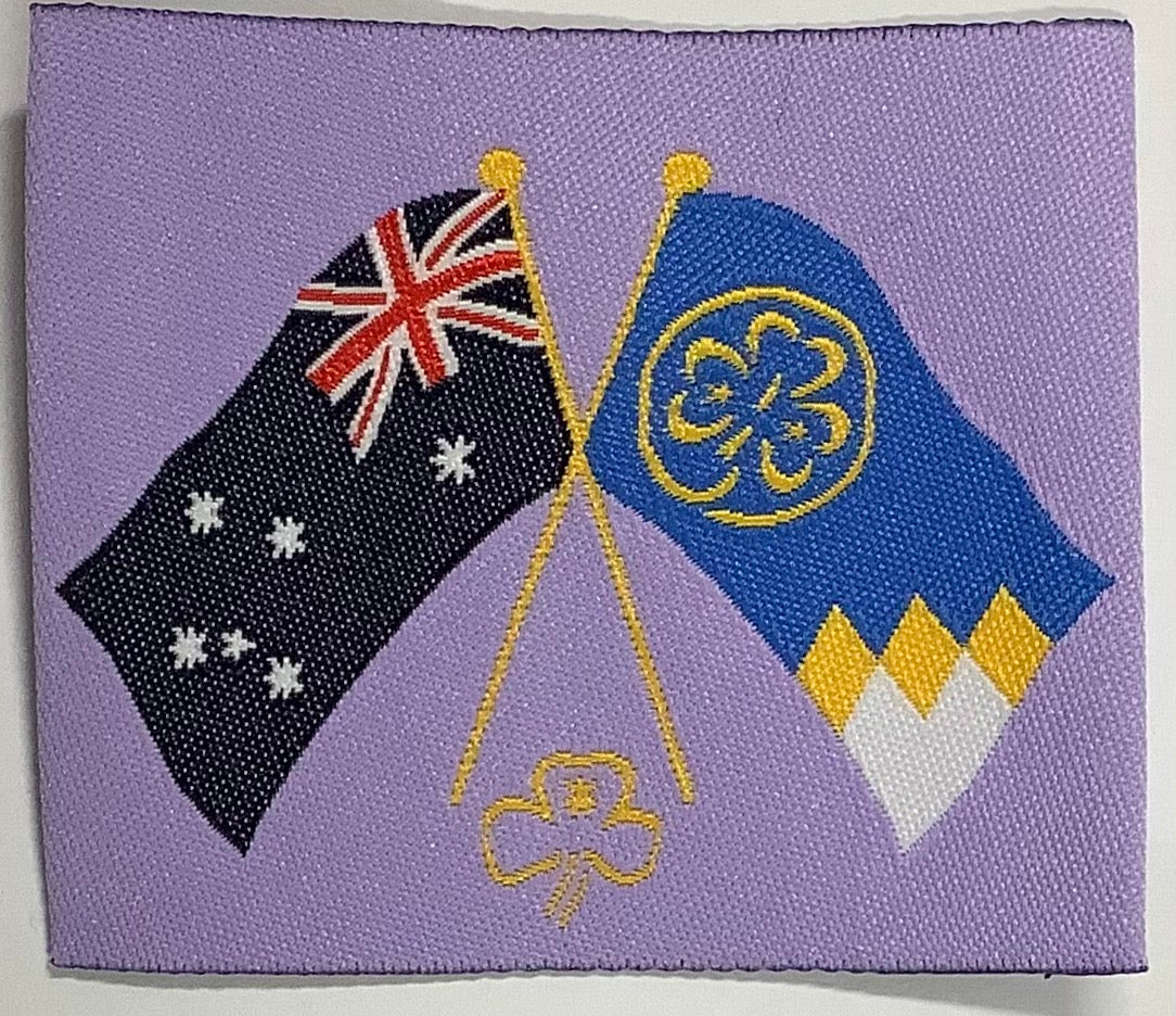 a square unbound light purple badge with the Australian and world flags with their poles intersecting