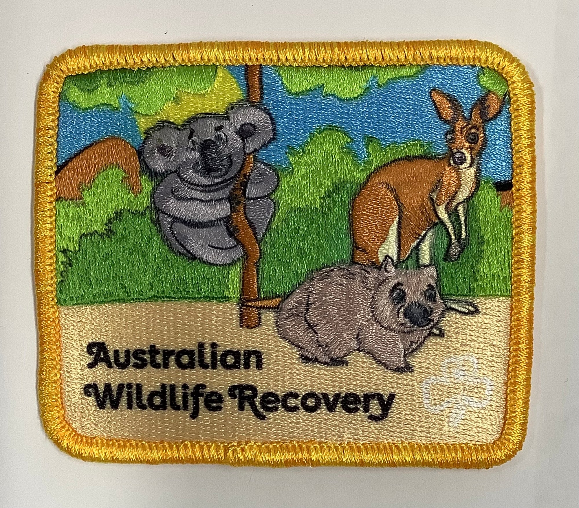 a square badge bound in gold with Australian native animals on it