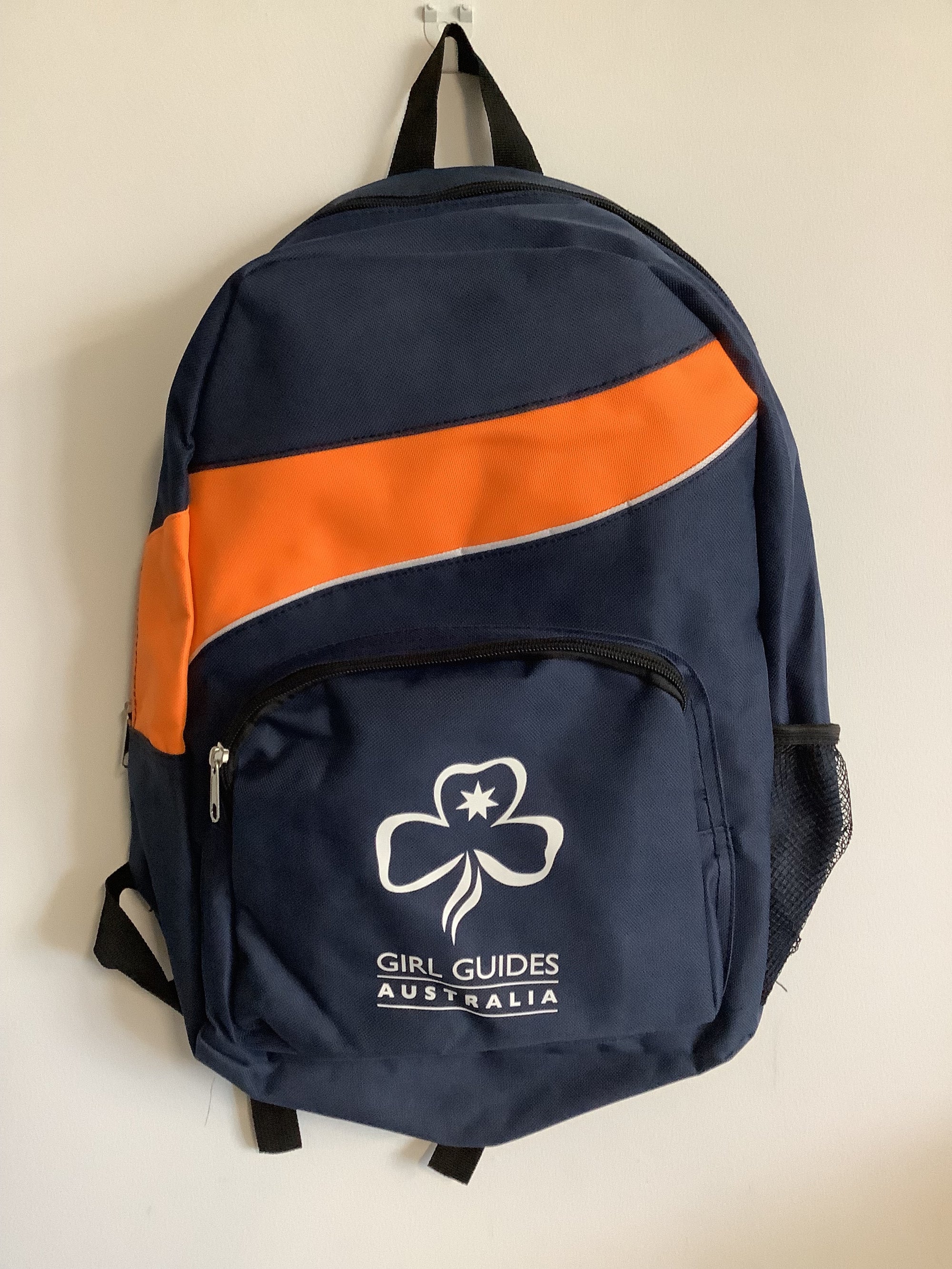 an orange and blue backpack with trefoil and girl guides Australia on the front pocket