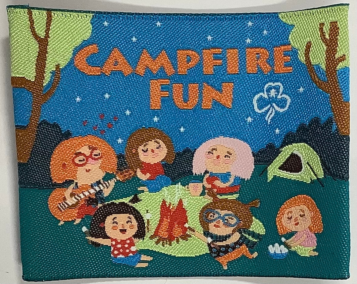 a square unbound badge with girls singing around a campfire