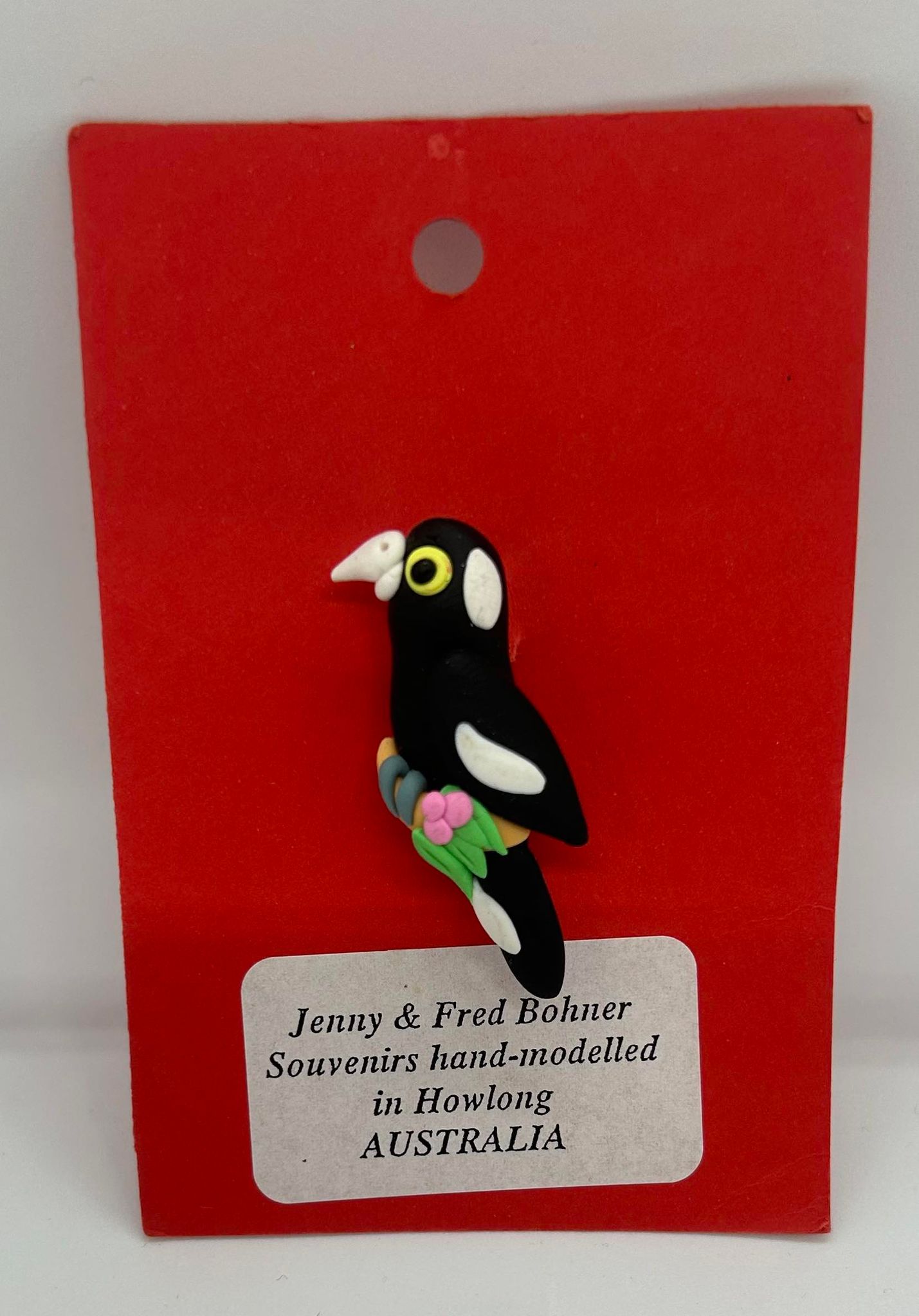 a clay badge of a black and white magpie