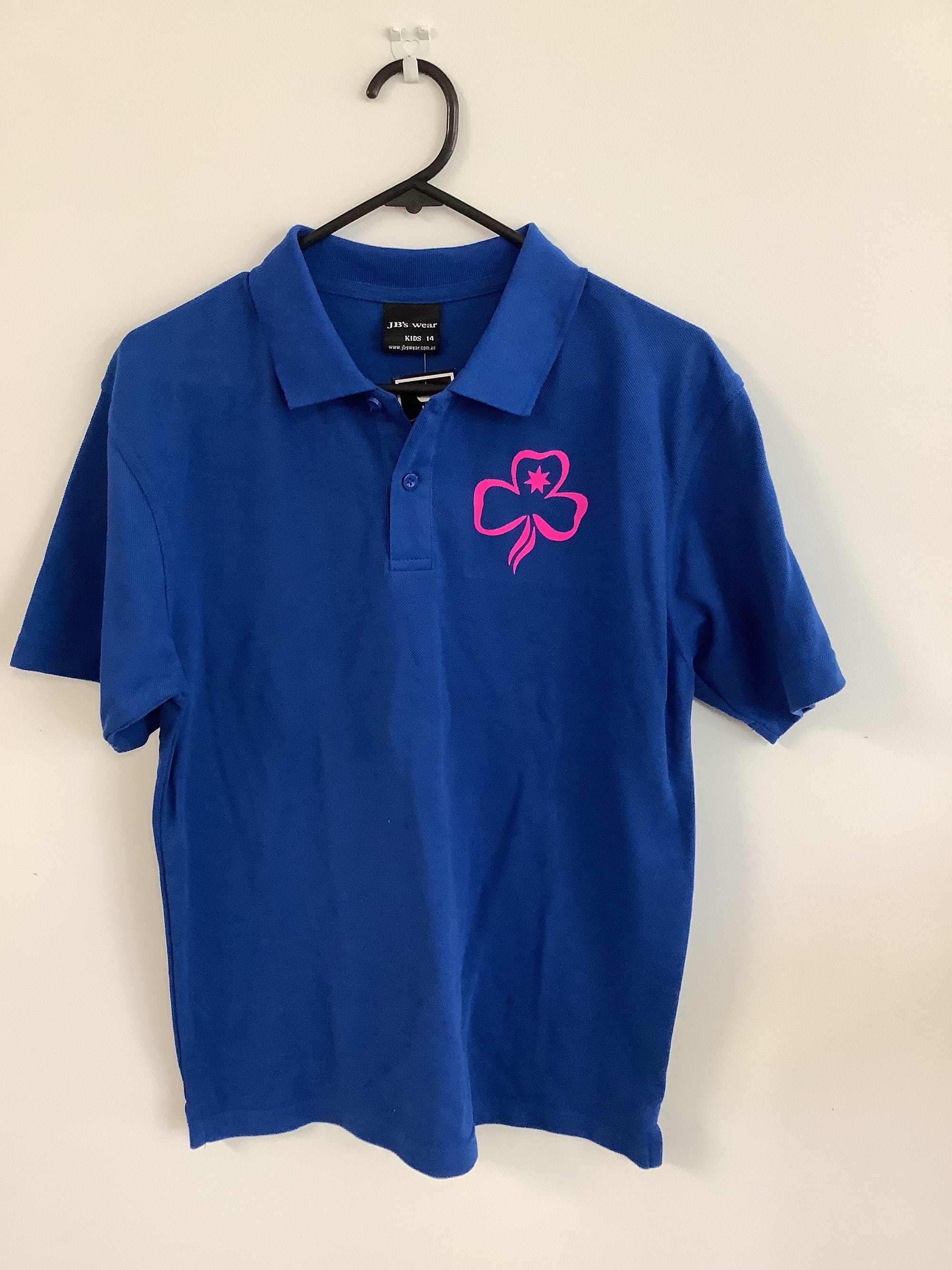 a navy polo shirt with a bright pink trefoil