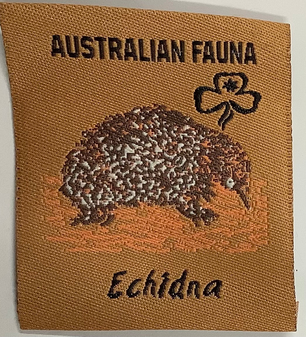 a square unbound badge that is brown with an echidna