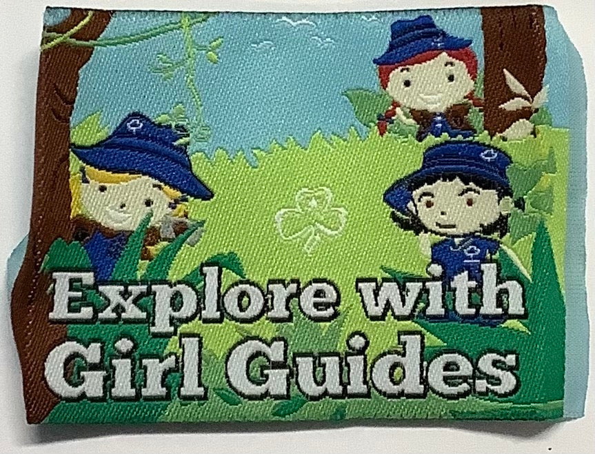 a square unbound badge with three guides out in the forest