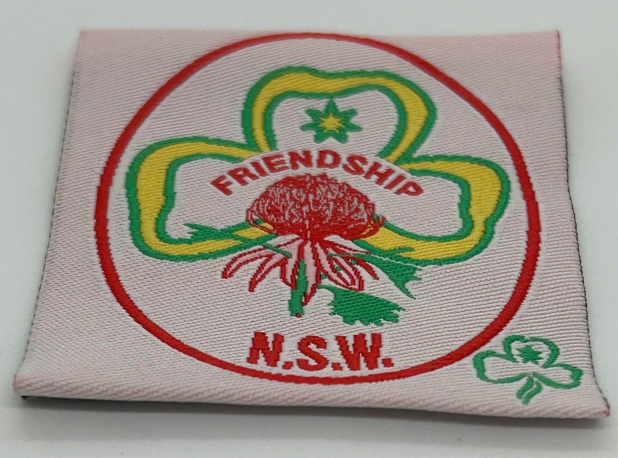 an unbound woven badge with the trefoil, the Waratah and friendship NSW