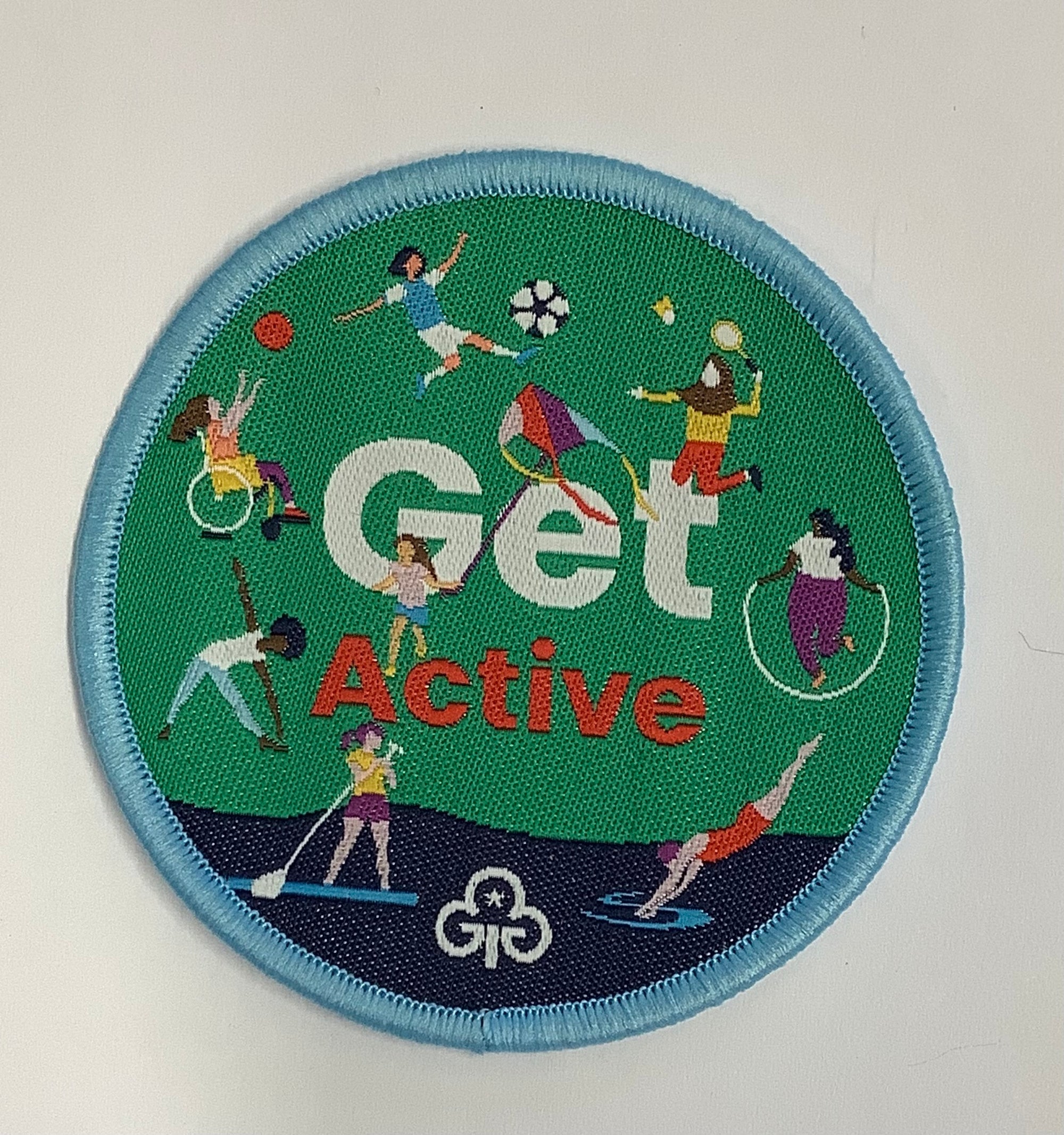 a round badge bound in light blue with girls doing lots of different sporting activities