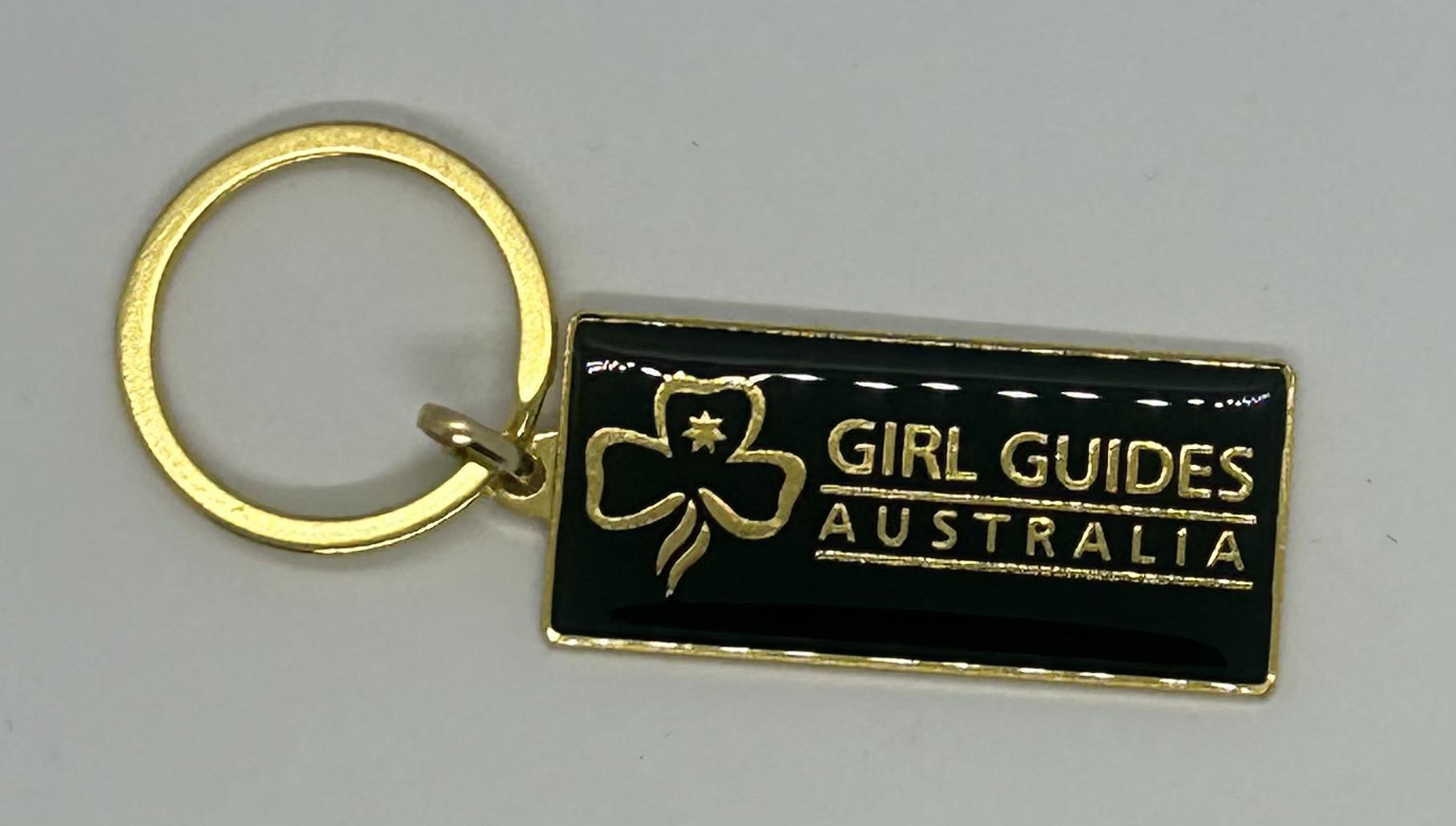 a metal key ring with the trefoil and girl guides australia