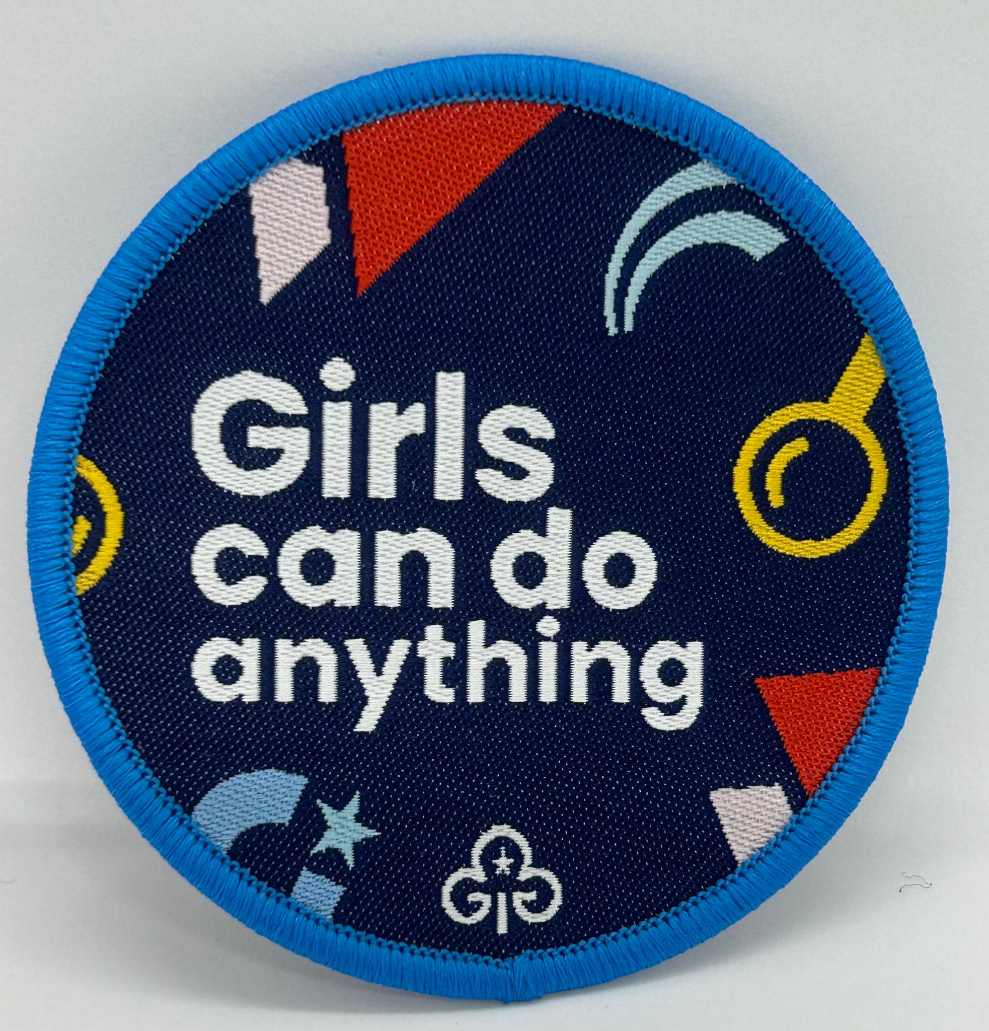 a round badge bound in blue with girls condo anything printed on it