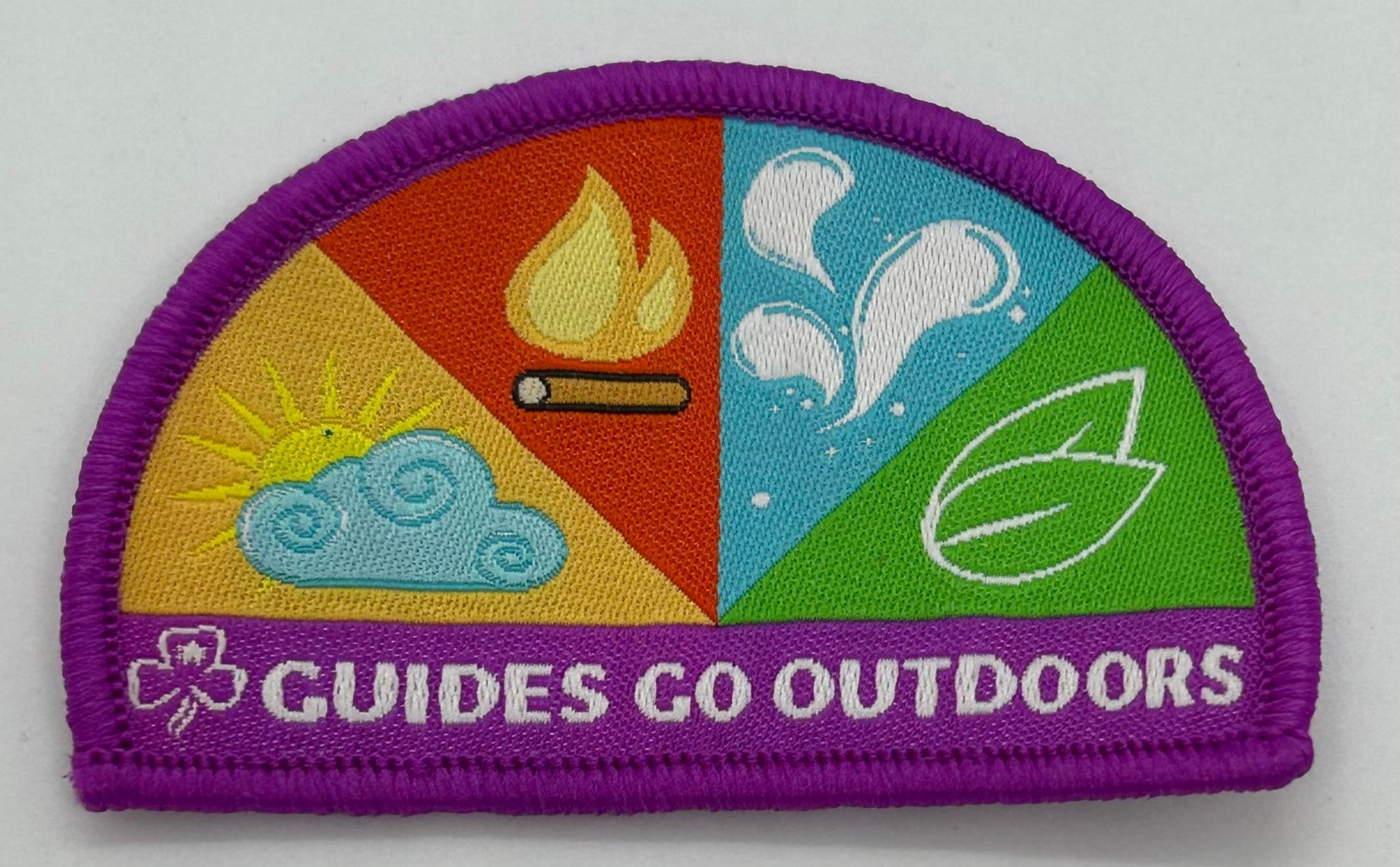 a semi circle shaped badge bound in purple that displays the elements of the syllabus on it