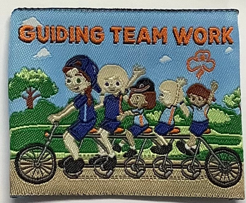 a square unbound badge with five guides riding an extended bike