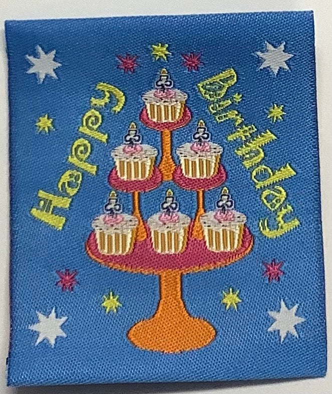 a square unbound blue badge with cupcakes on a stand