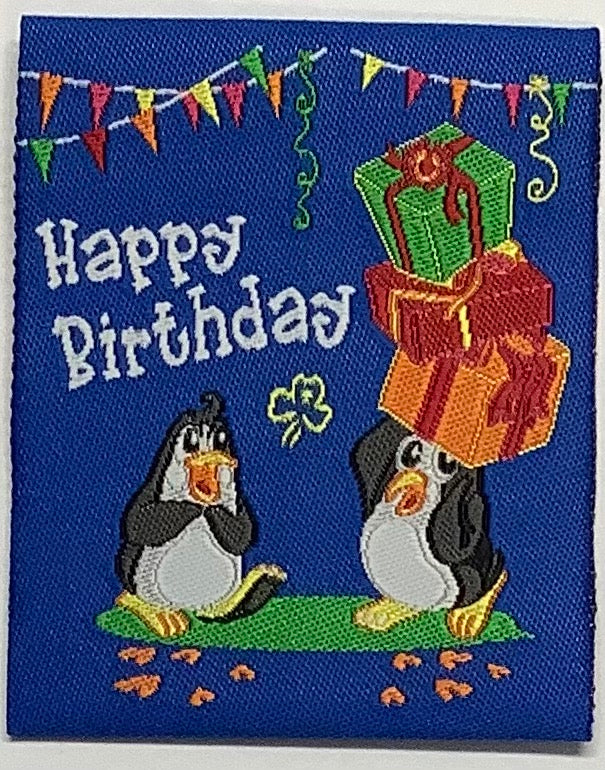 a square unbound badge that is blue with two penguins and presents