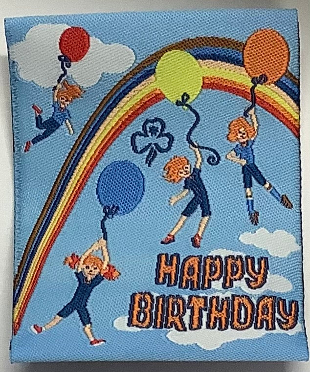 a square unbound light blue badge with a rainbow and guides with balloons