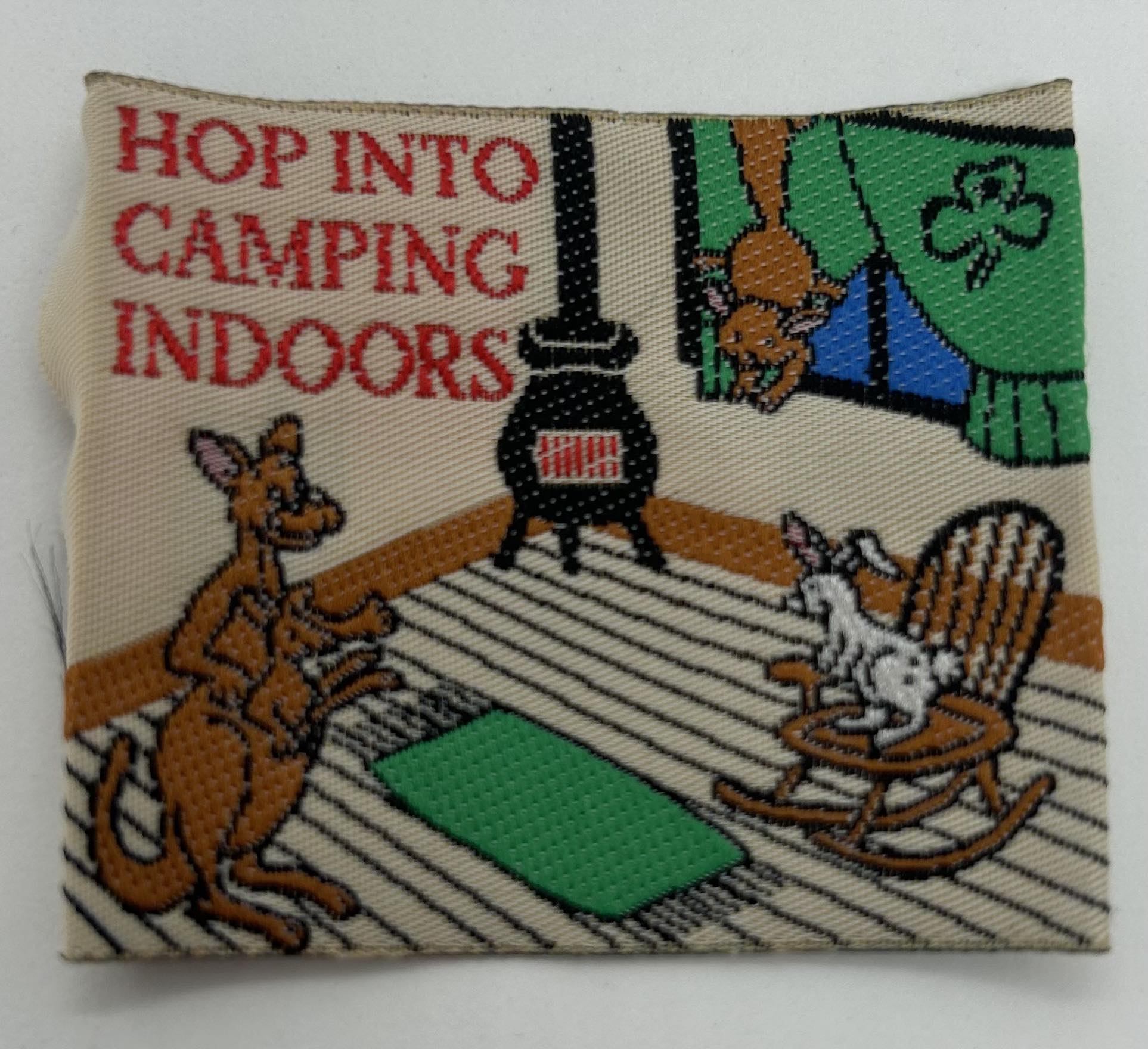 a square unbound woven badge with a kangaroo and joey with other animals indoors