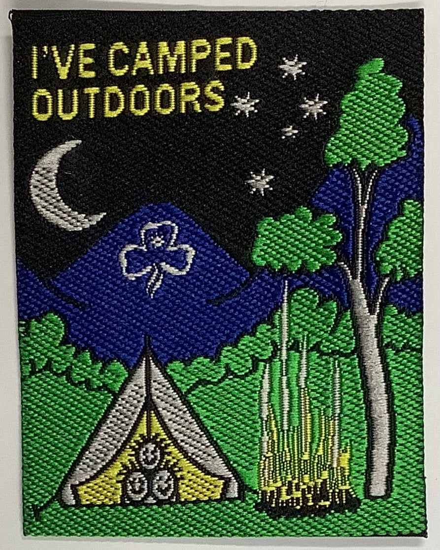 a square unbound badge with a night scene with a tent and campfire