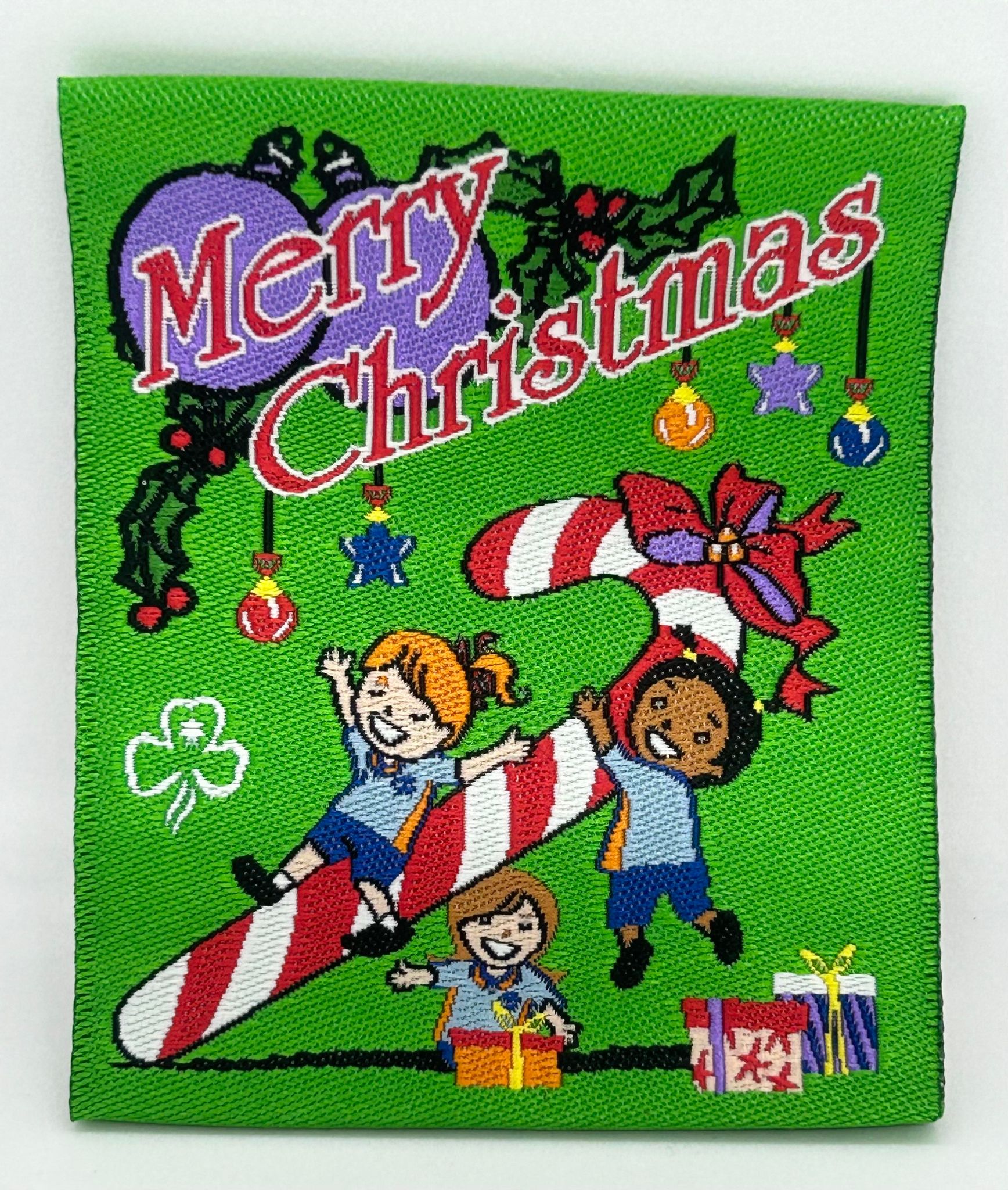 a square green unbound badge that has guides, presents, decorations and a candy cane
