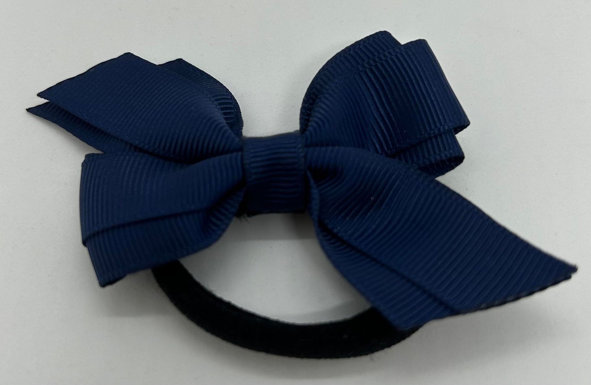a navy blue bow on a hair tie